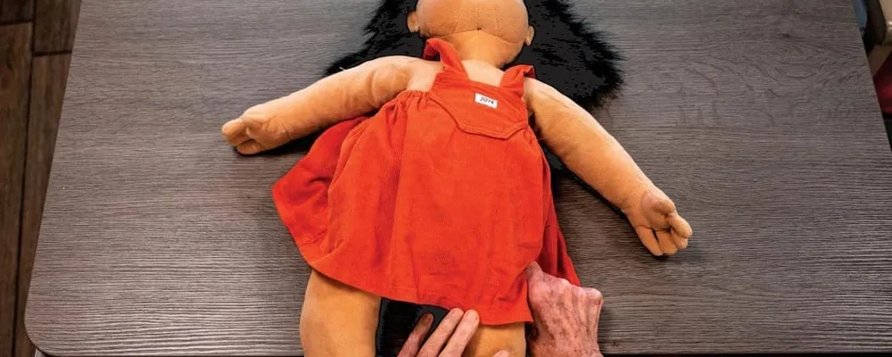 Un anziano durante una terapia che prevede l;utilizzo di una bambola per stimolare l&#39;affettivit&agrave; e l'accudimento