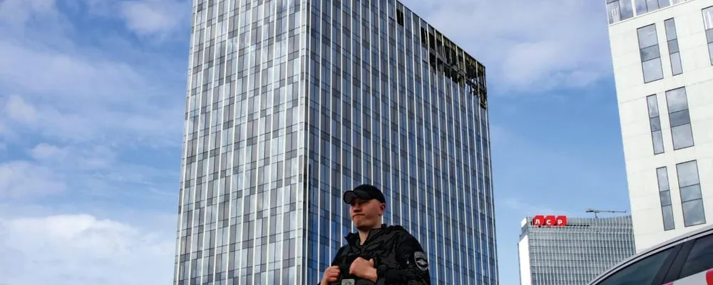 <p>Un poliziotto davanti a un centro commerciale danneggiato dai droni a Mosca, lo scorso luglio</p>
