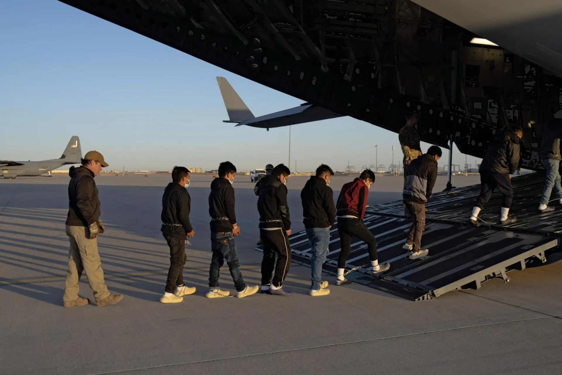 Lo scorso 23 gennaio, agenti della Customs and Border Protection Usa fanno salire un gruppo di migranti irregolari su un aereo militare per la prima espulsione da Fort Bliss verso il Guatemala