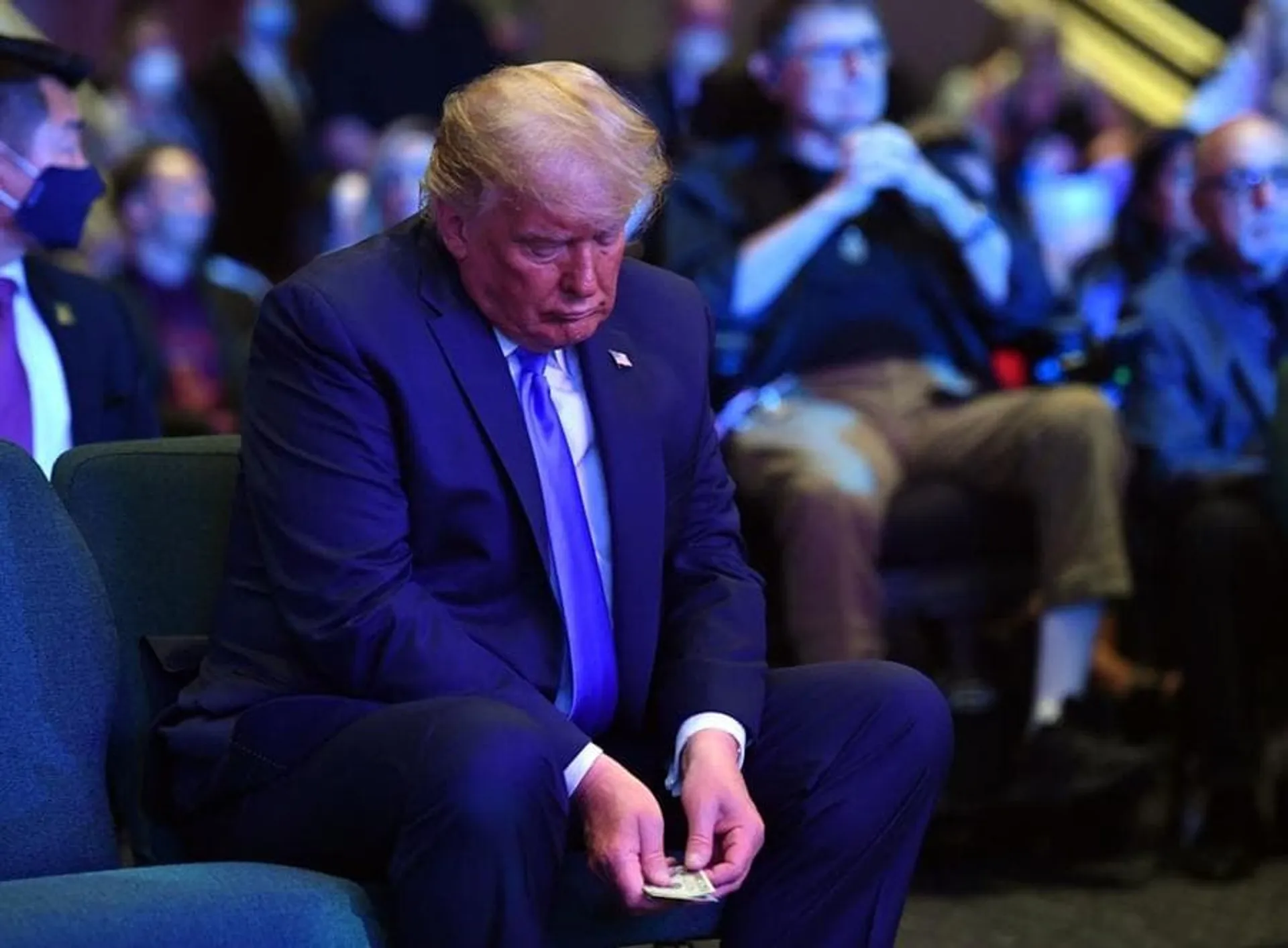 US President Donald Trump counts money before making an offering, as he attends services at the International Church of Las Vegas in Las Vegas, Nevada on October 18, 2020. - President Donald Trump and rival Joe Biden hit the ground Sunday in the swing states that will decide the US election, as the campaign turns increasingly vicious 16 days before voting. Trump, scrambling to make up lost ground, is on a furious multi-state barnstorming tour hopping from Nevada to California and then back to Nevada for a day of rallies and fundraising. (Photo by MANDEL NGAN / AFP) (Photo by MANDEL NGAN/AFP via Getty Images)