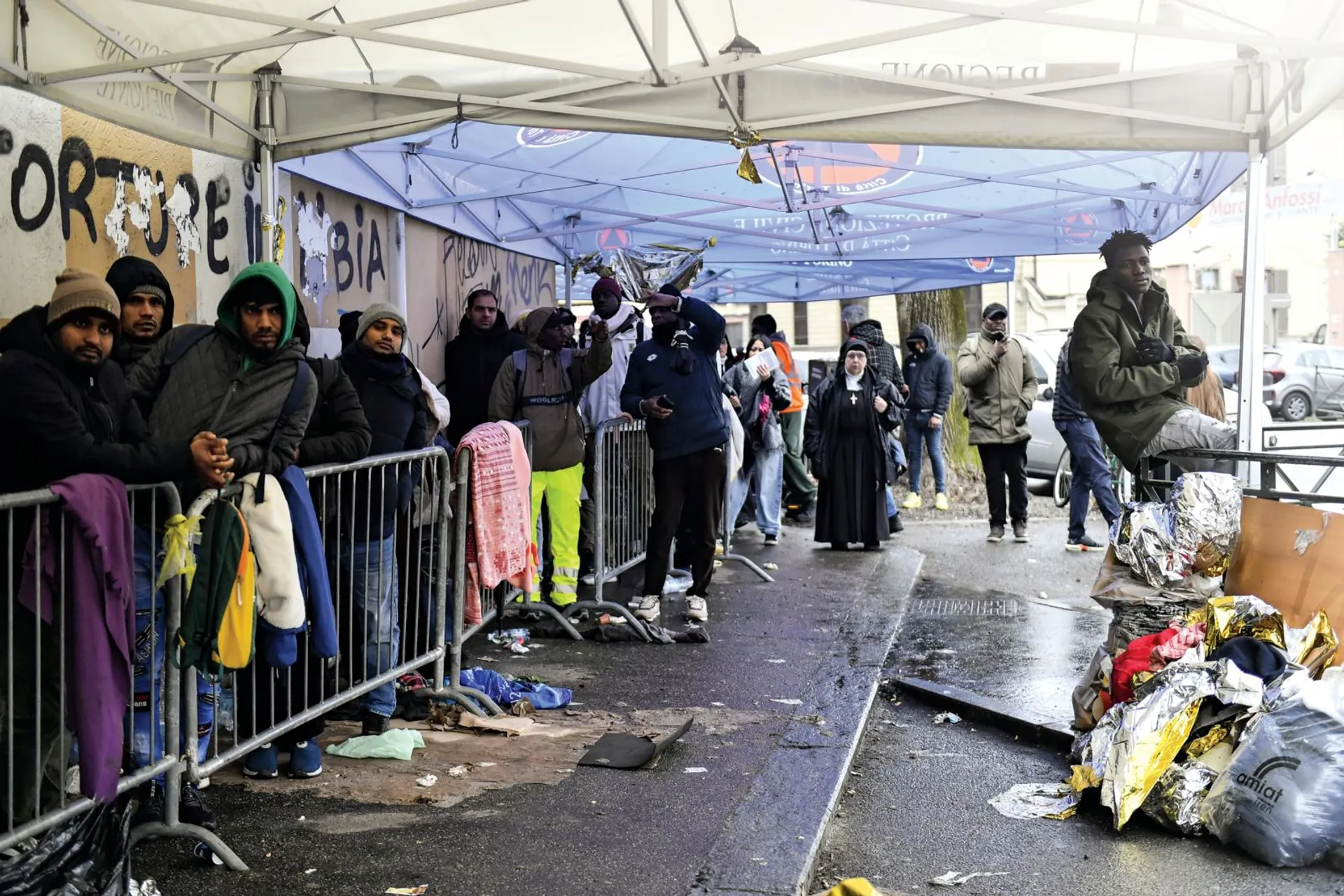 Migranti costretti a lunghe code fuori dalla Questura di Torino, lo scorso gennaio