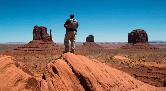 TOPSHOT - A Navajo park ranger looks out over Navajo Nation managed Monument Valley Tribal Park, which has been closed due to the Covid-19 pandemic in Arizona on May 21, 2020. - Weeks of delays in delivering vital coronavirus aid to Native American tribes exacerbated the outbreak, the president of the hard-hit Navajo Nation said, lashing the administration of President Donald Trump for botching its response. Jonathan Nez told AFP in an interview that of the $8 billion promised to US tribes in a $2.2 trillion stimulus package passed in late March, the first tranche was released just over a week ago. (Photo by Mark RALSTON / AFP) (Photo by MARK RALSTON/AFP via Getty Images)