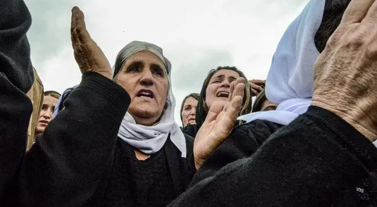 Iraqi Yazidi women mourn during a ceremony during the exhumation of a mass-grave of hundreds of Yazidis killed by Islamic State (IS) group militants in the northern Iraqi village of Kojo in Sinjar district on March 15, 2019. - Iraqi authorities exhumed the mass grave in an operation aiming to extract remains and identify victims of an August 2014 massacre of Yazidis by IS fighters as they entered the village of Kojo, during investigations of genocide against the decimated minority. (Photo by Zaid AL-OBEIDI / AFP)        (Photo credit should read ZAID AL-OBEIDI/AFP via Getty Images)