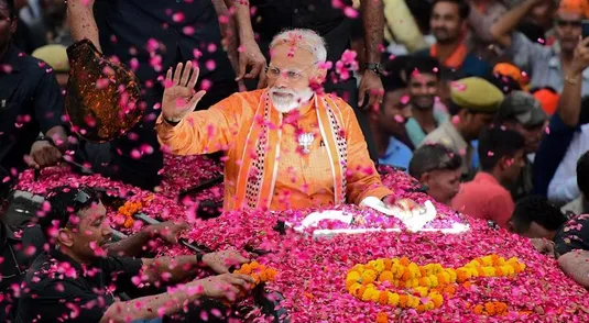 TOPSHOT - Indian Prime Minister and leader of the Bharatiya Janata Party (BJP) Narendra Modi gestures during a roadshow in Varanasi on April 25, 2019. - Tens of thousands of followers of Indian Prime Minister Narendra Modi packed the streets of his political bastion on April 25 as he stepped up campaigning in the country's marathon election. (Photo by SANJAY KANOJIA / AFP)        (Photo credit should read SANJAY KANOJIA/AFP/Getty Images)