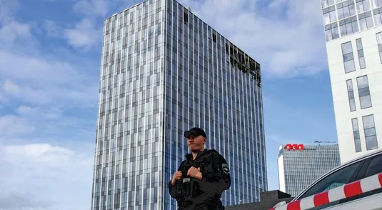 <p>Un poliziotto davanti a un centro commerciale danneggiato dai droni a Mosca, lo scorso luglio</p>

