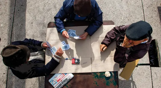 pensionati giocano a carte in un parco di Lisbona