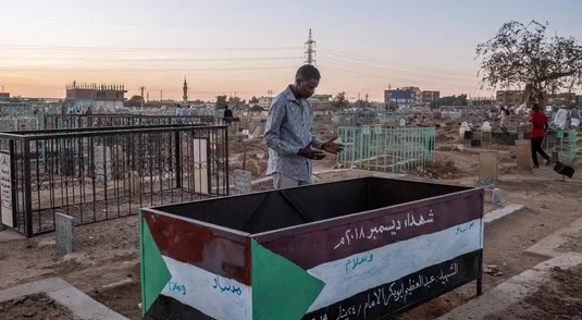 A man praying on the tomb of one of the Martyr of the Sudan's revolution at the Sheikh Hamed al-Nil cemetery where every Friday afternoon the Sufi meet to perform their dances and prayers near their leaders' tombs.